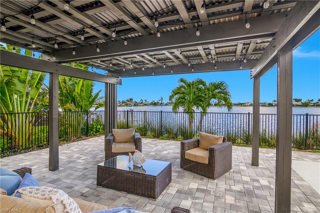 Fenced backyard with outdoor lounge area, a water view, and a patio