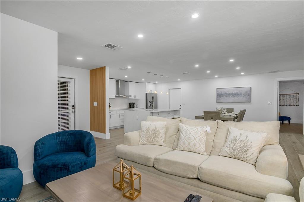 Living room with light wood-style flooring and recessed lighting
