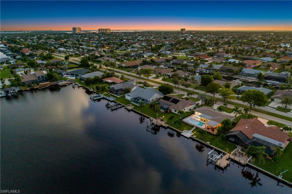 Aerial view of property and surrounding area with a nearby body of water and nearby suburban area