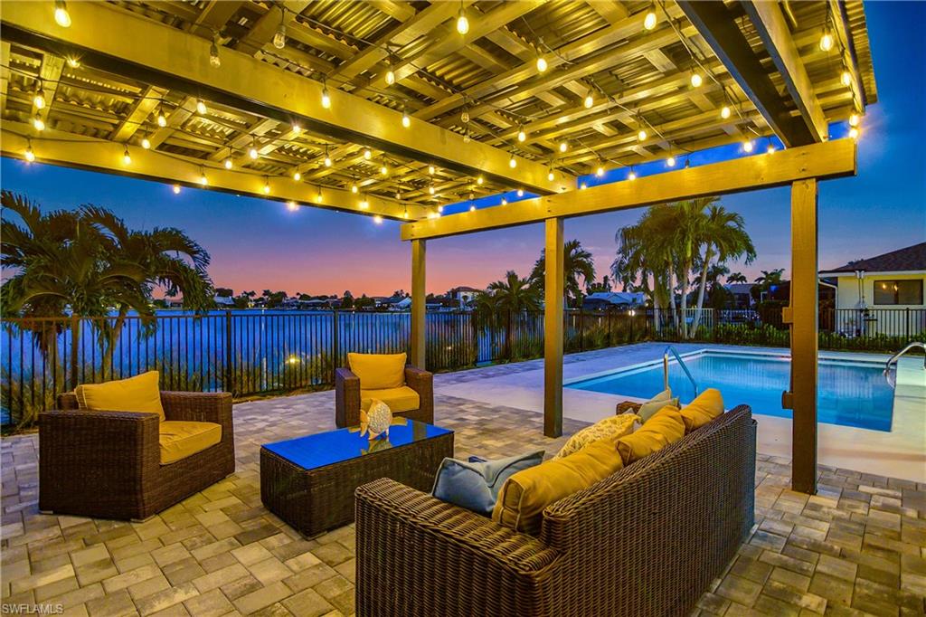 Community pool with an outdoor hangout area, a fenced backyard, a patio area, and a water view