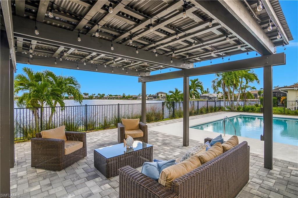 View of pool featuring a patio, an outdoor hangout area, a fenced backyard, and a water view
