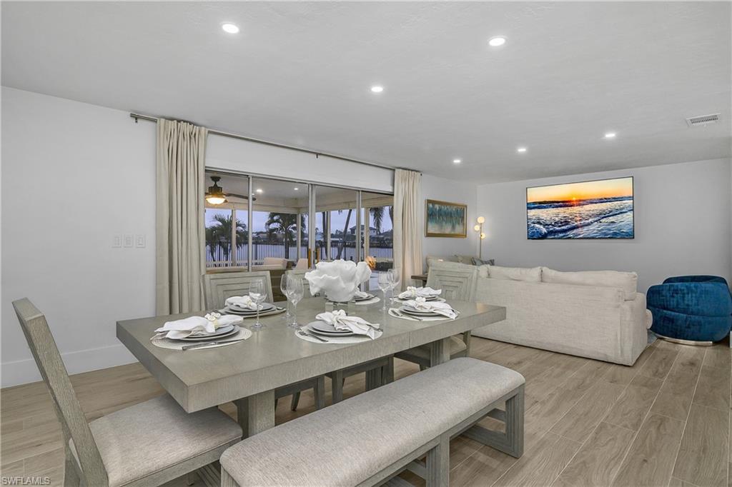 Dining space with light wood-type flooring, recessed lighting, a water view, and a ceiling fan