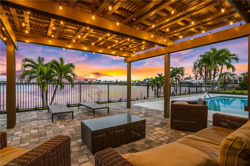 Patio terrace at dusk featuring a fenced backyard, a patio area, an outdoor hangout area, and a water view