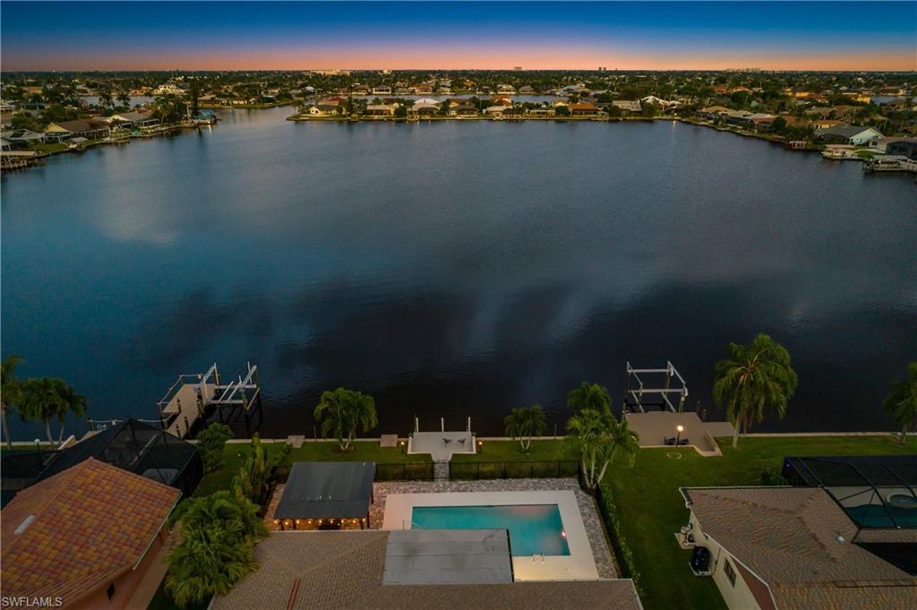 Aerial perspective of suburban area featuring a pool area and a large body of water