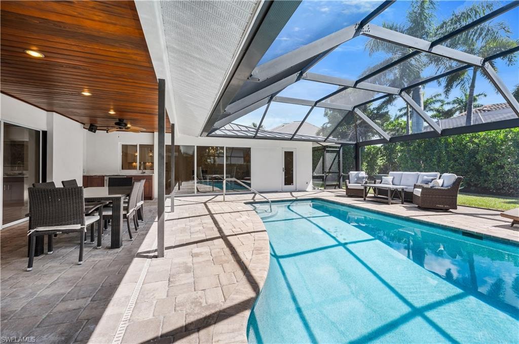 Living area featuring vaulted ceiling, a sunroom, recessed lighting, and a chandelier