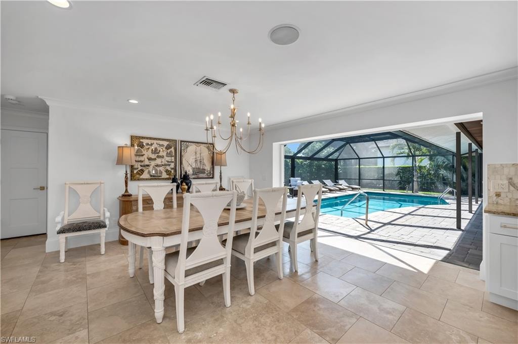 Dining room featuring crown molding, recessed lighting, a sunroom, a chandelier, and light tile patterned flooring