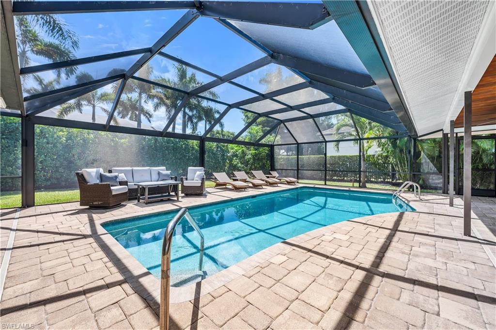 Outdoor pool with a lanai, a sunroom, a patio area, and an outdoor living space