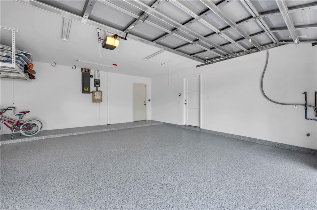 Garage featuring a garage door opener and electric panel