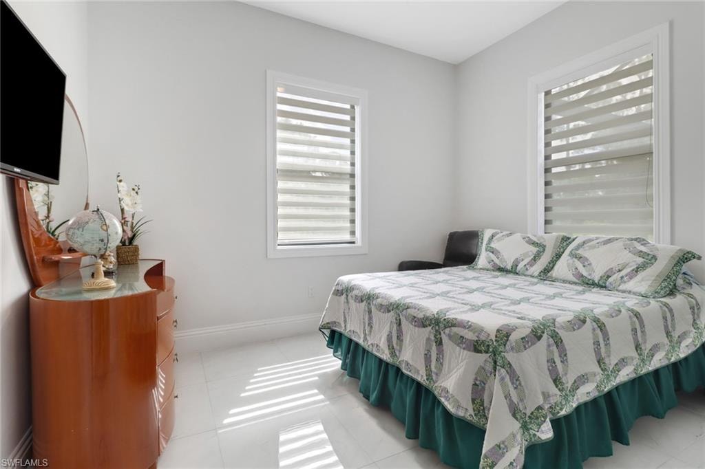 Bedroom featuring light tile patterned floors and baseboards