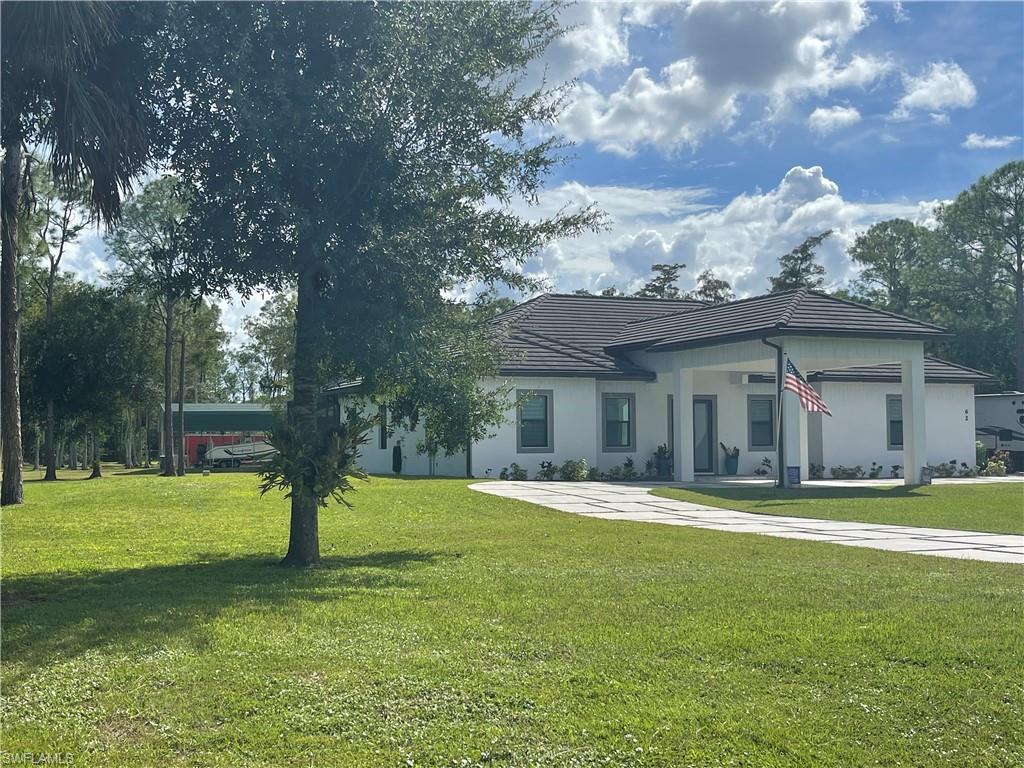 Single story home featuring a front lawn and stucco siding