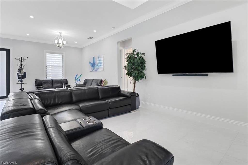 Living area featuring crown molding, recessed lighting, a chandelier, and tile patterned flooring