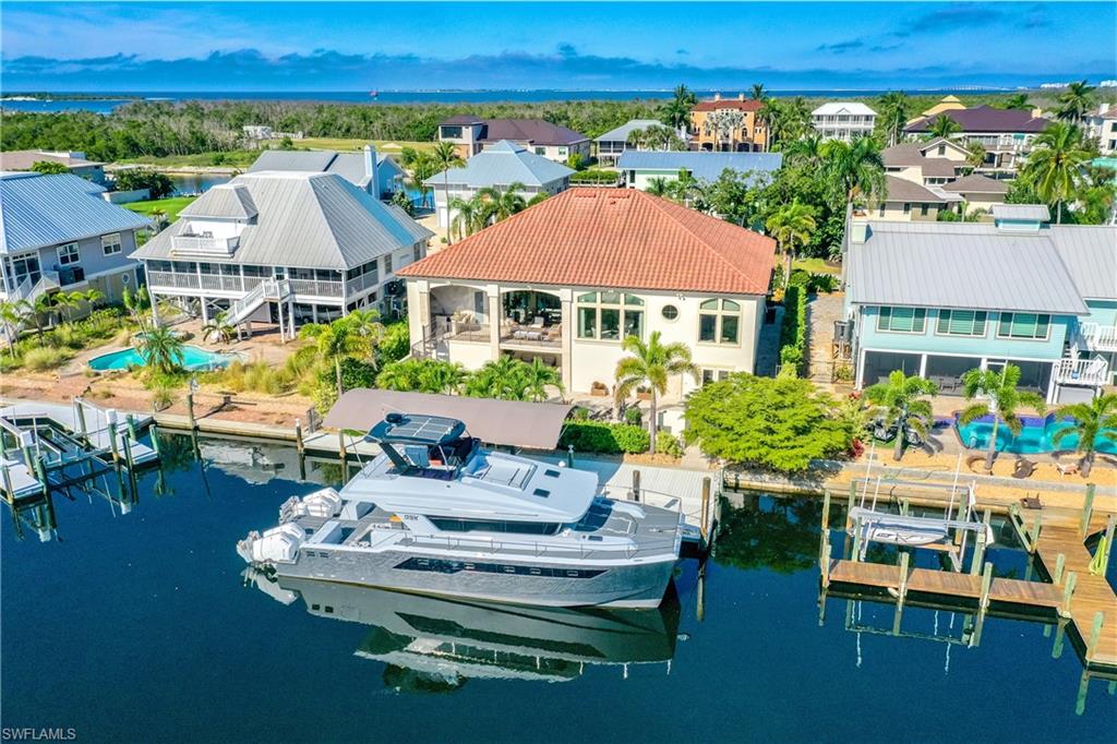 Drone / aerial view of a nearby body of water and a pool area
