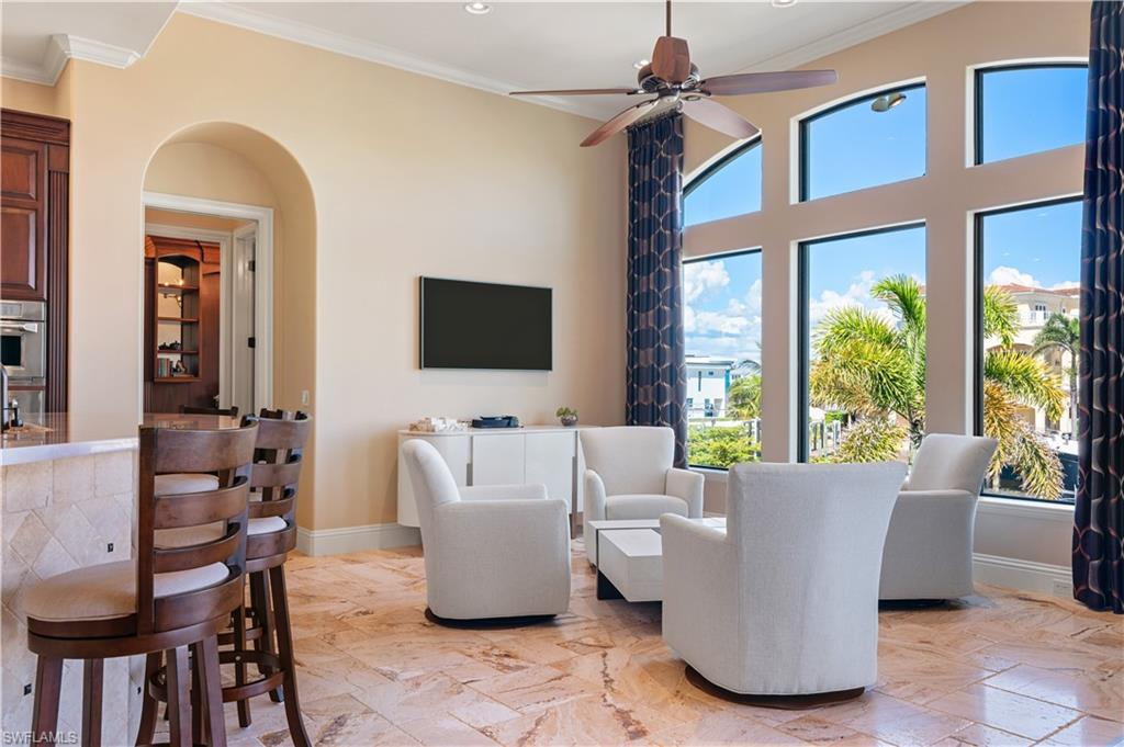 Living room featuring crown molding, a ceiling fan, recessed lighting, and arched walkways