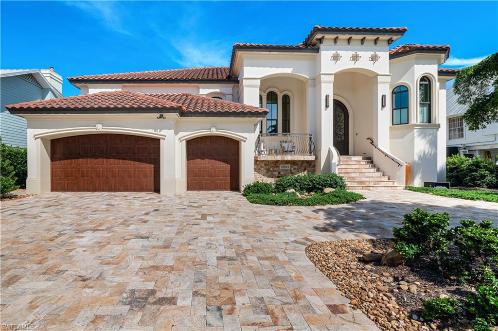 Mediterranean / spanish-style home with stucco siding, an attached garage, decorative driveway, and a tiled roof