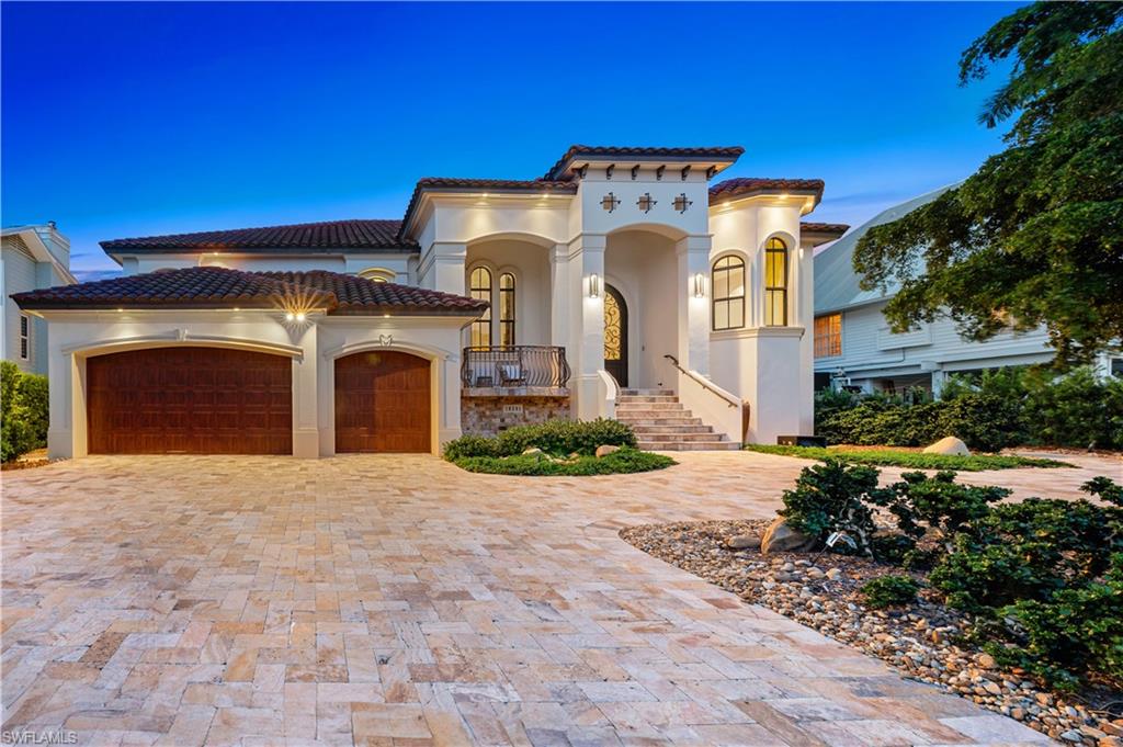 Mediterranean / spanish-style home with stucco siding, decorative driveway, an attached garage, and a tiled roof