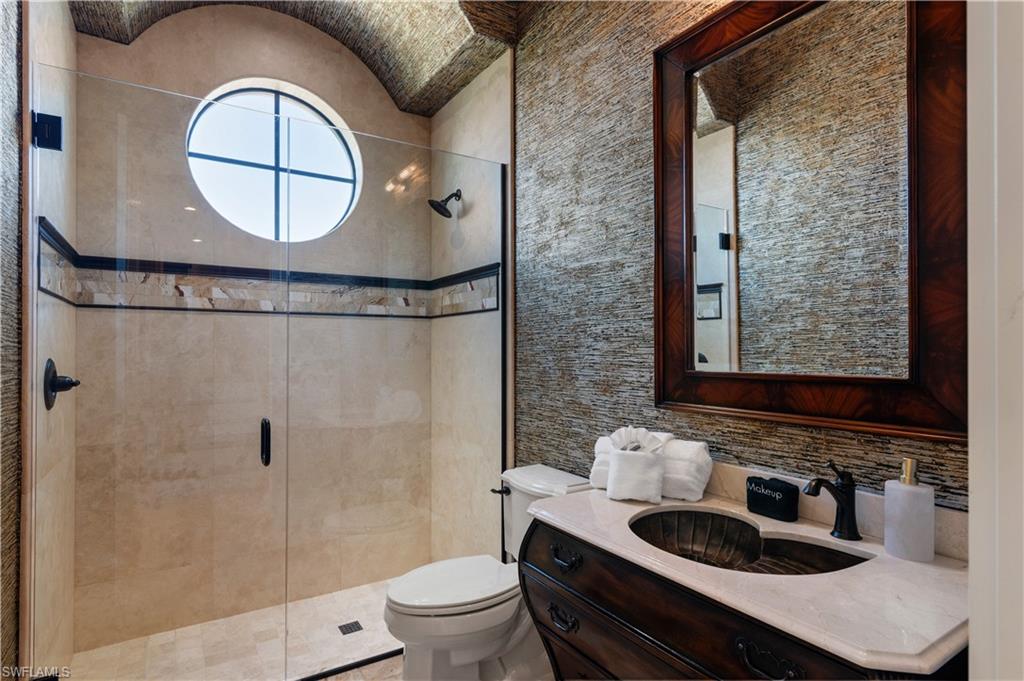 Full bathroom with a stall shower, vanity, and backsplash