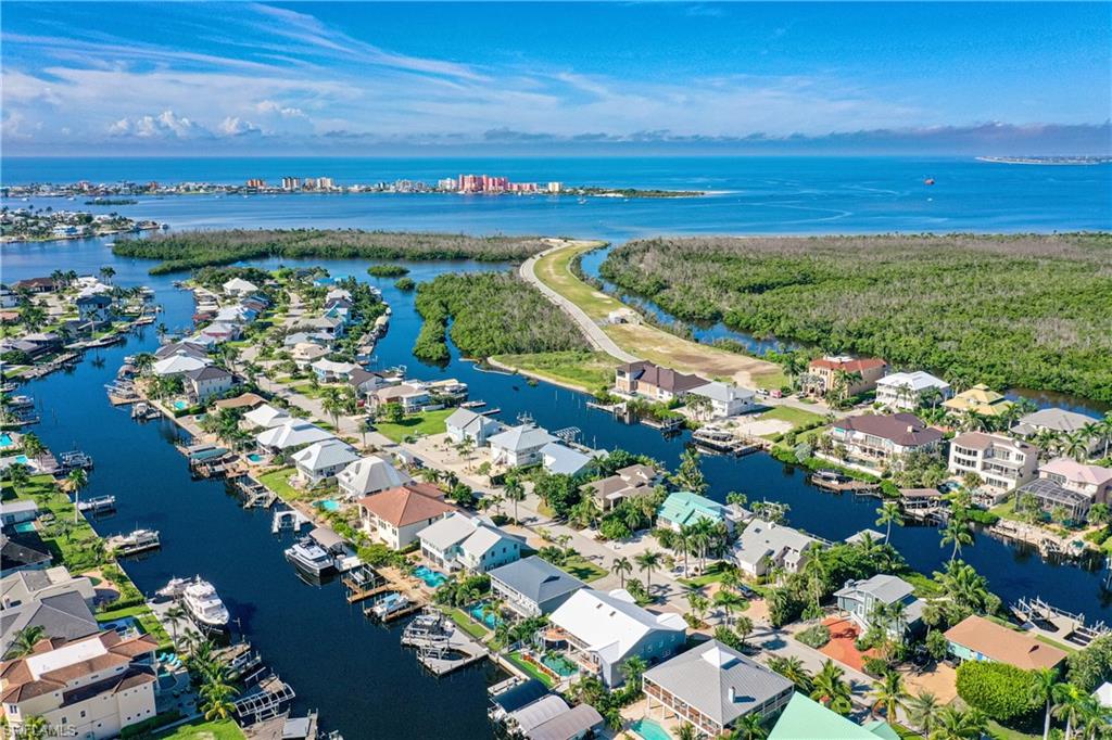 Aerial view of property and surrounding area featuring a nearby body of water and nearby suburban area