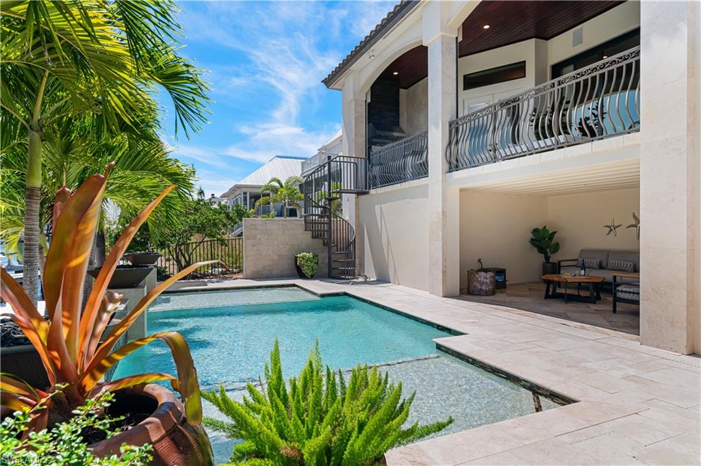 Outdoor pool featuring stairway, a patio area, and a balcony