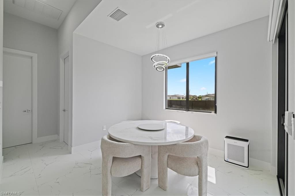 Dining area featuring light marble finish flooring and a chandelier
