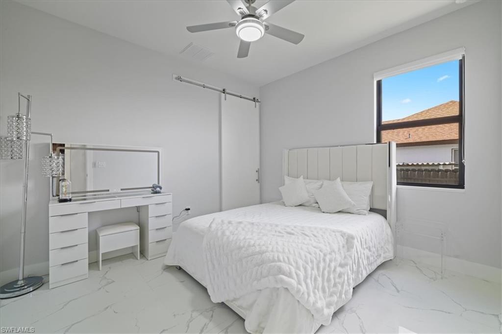 Bedroom with marble finish flooring and a ceiling fan