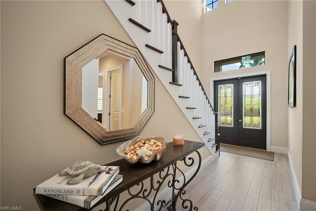 Entrance foyer featuring wood finished floors, french doors, stairs, and a high ceiling