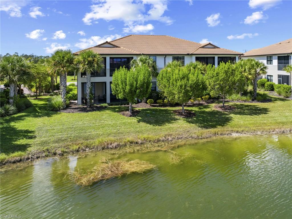Pond and fountain view with mature landscaping