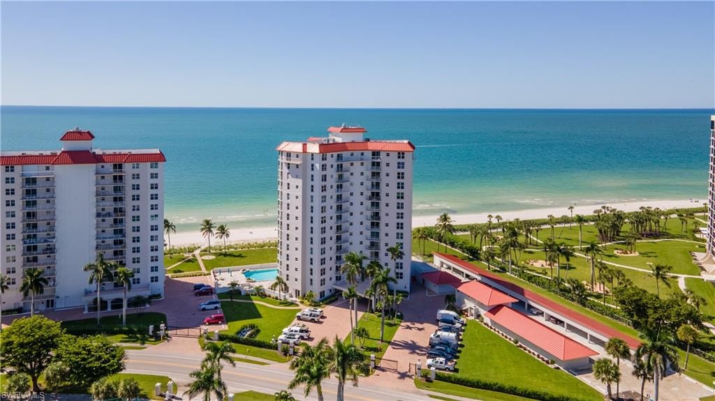 Drone / aerial view of waterfront with a beach and apartment complex / building