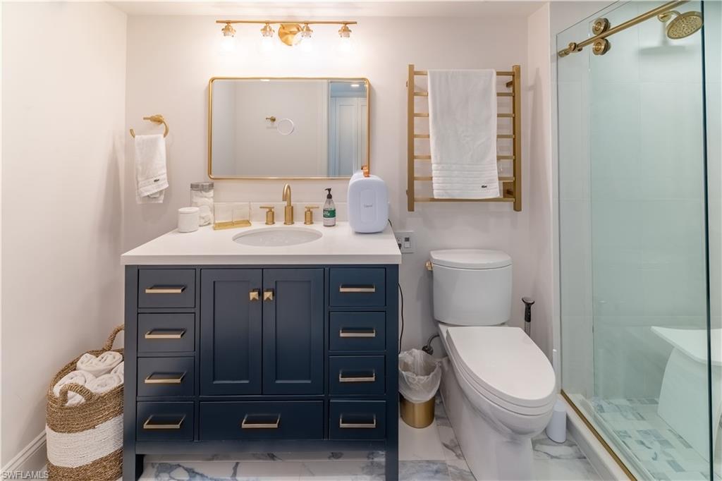 Full bathroom with vanity, a stall shower, and light marble finish floors
