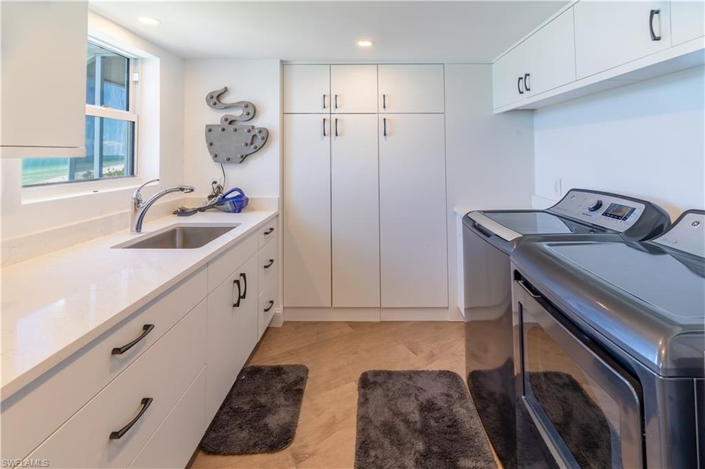 Laundry room with cabinet space, washing machine and clothes dryer, recessed lighting, and light tile patterned flooring