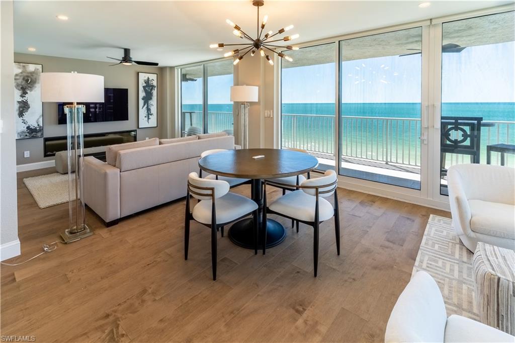 Dining area with light wood-style flooring, a chandelier, recessed lighting, a ceiling fan, and expansive windows
