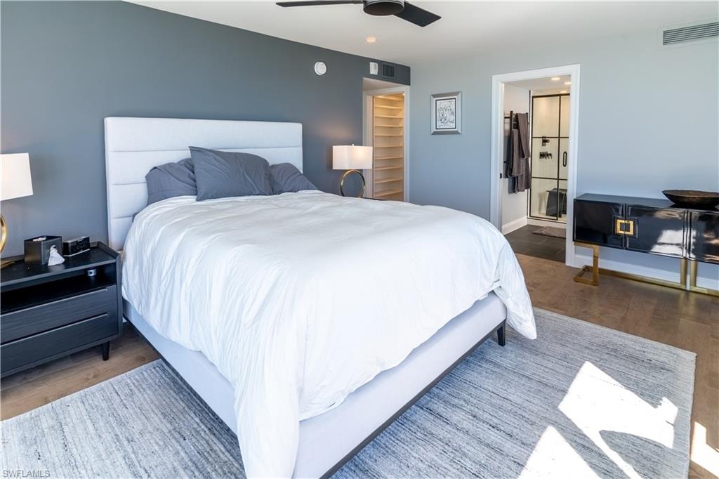Bedroom featuring wood finished floors, ceiling fan, and connected bathroom