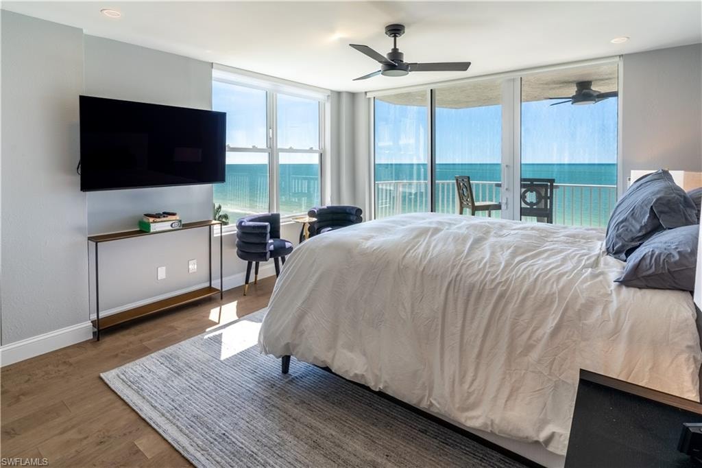 Bedroom with wood finished floors, access to outside, and ceiling fan