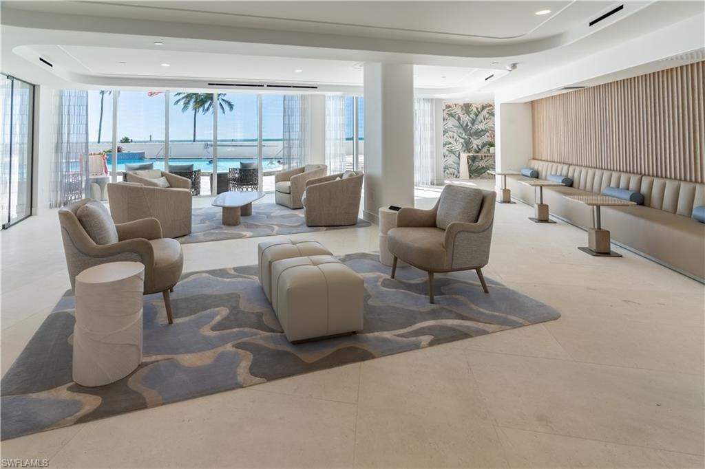 Building lobby with floor to ceiling windows, a water view, and recessed lighting