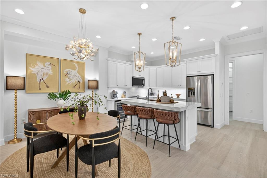 Dining room featuring recessed lighting, crown molding, light wood-type flooring, and a chandelier