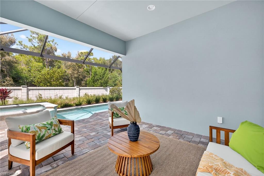 View of pool with a patio, a lanai, and a pool with connected hot tub