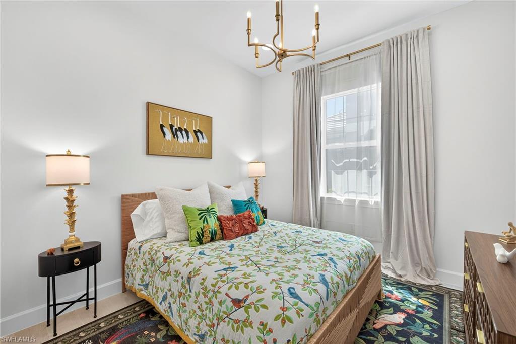 Bedroom featuring baseboards and a chandelier