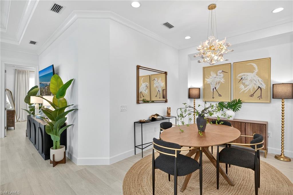 Dining room with light wood-style flooring, crown molding, recessed lighting, and a chandelier
