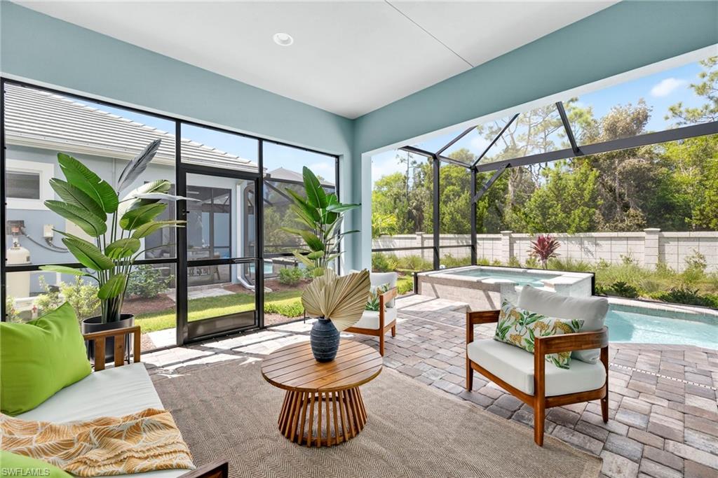 Sunroom / solarium with a hot tub and a patio