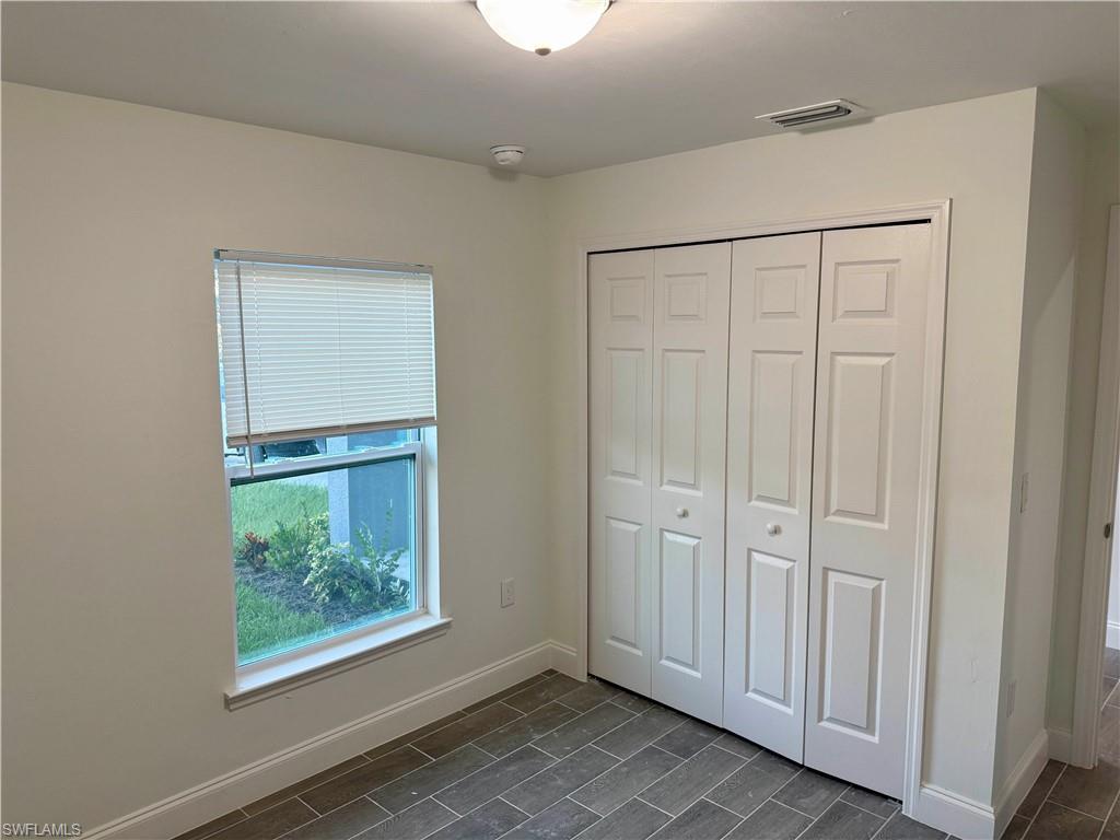 Unfurnished bedroom with a closet and wood finish floors