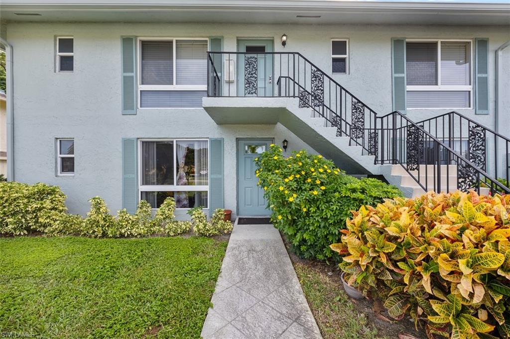 Doorway to property featuring stucco siding and a lawn
