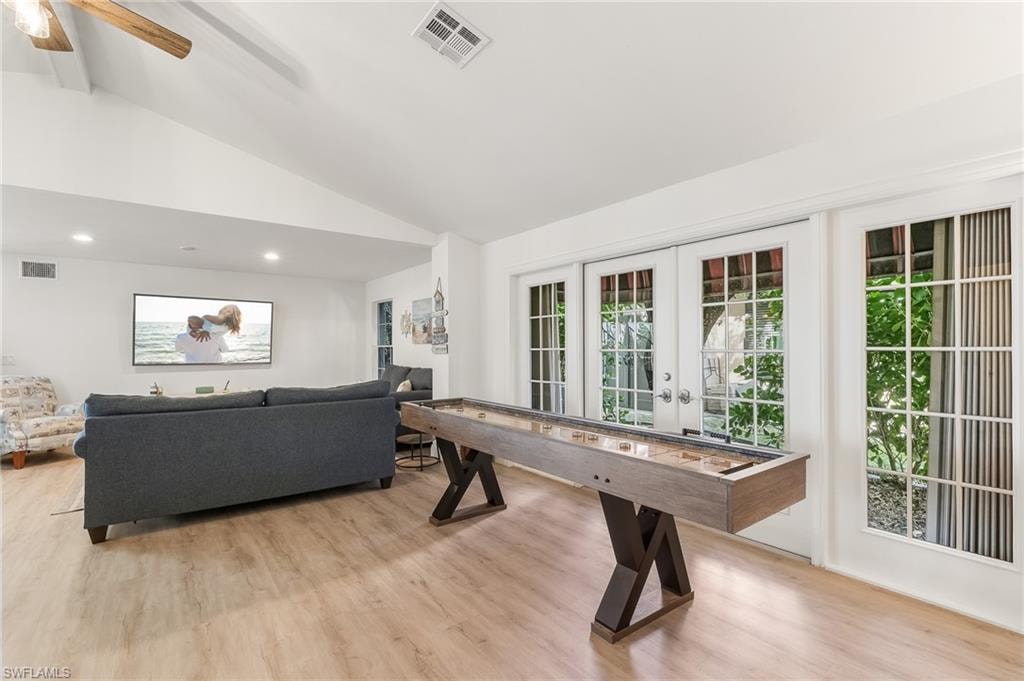 Playroom featuring light wood-style floors, french doors, beamed ceiling, high vaulted ceiling, and ceiling fan