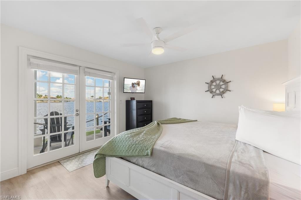 Bedroom featuring access to outside, french doors, wood finished floors, and a ceiling fan