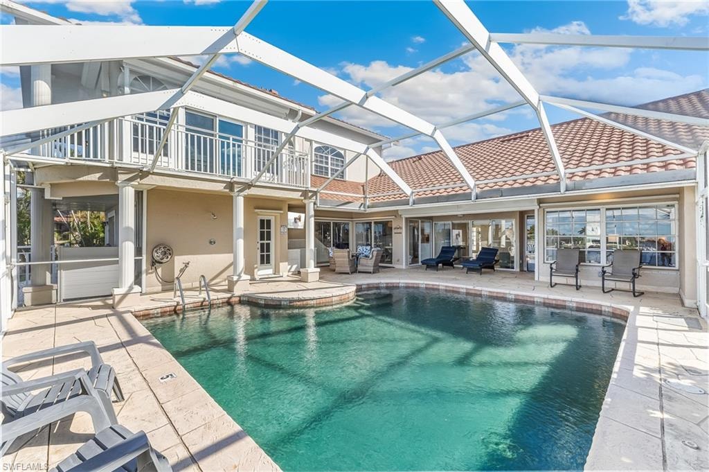 Outdoor pool featuring a sunroom, a patio area, a lanai, and an outdoor hangout area