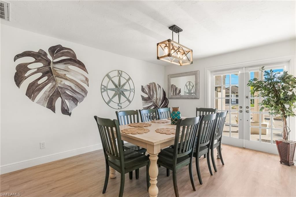 Dining room with french doors and light wood-type flooring