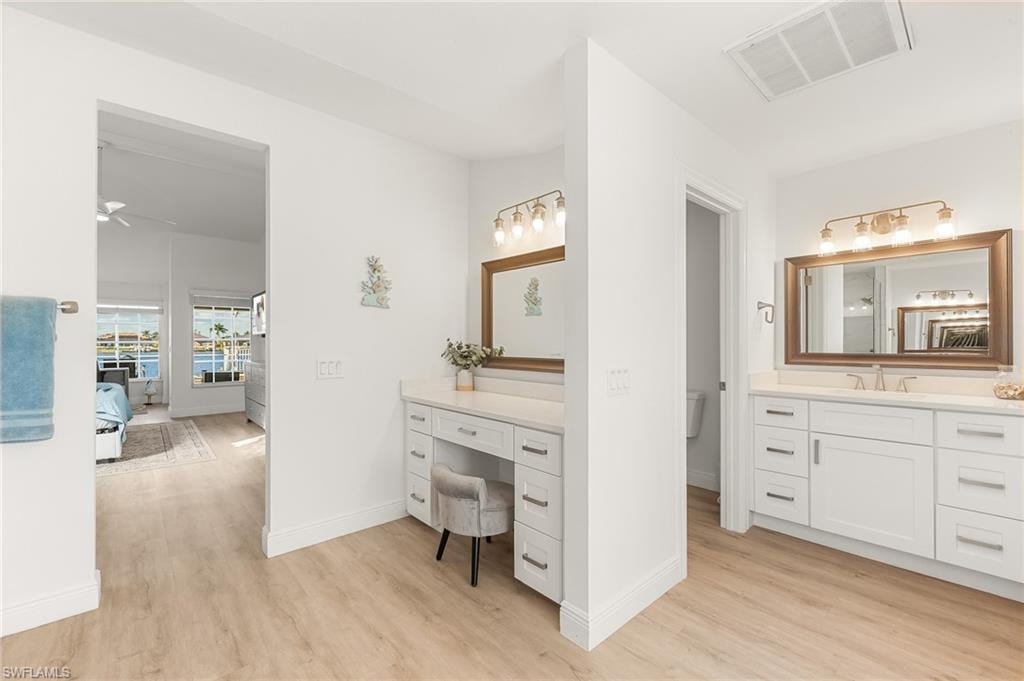 Bathroom with light wood-type flooring, vanity, and a ceiling fan