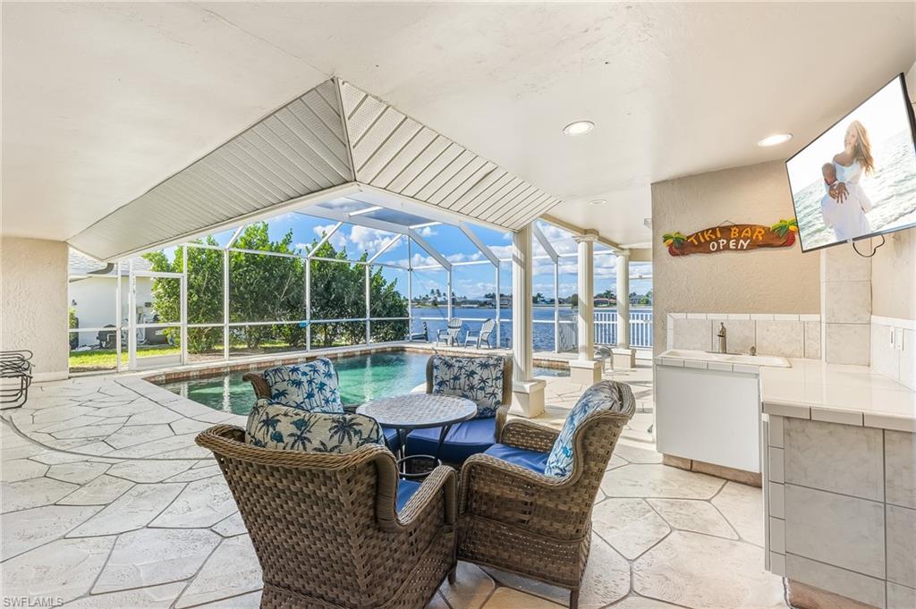 View of patio with a sunroom, a lanai, and an outdoor pool