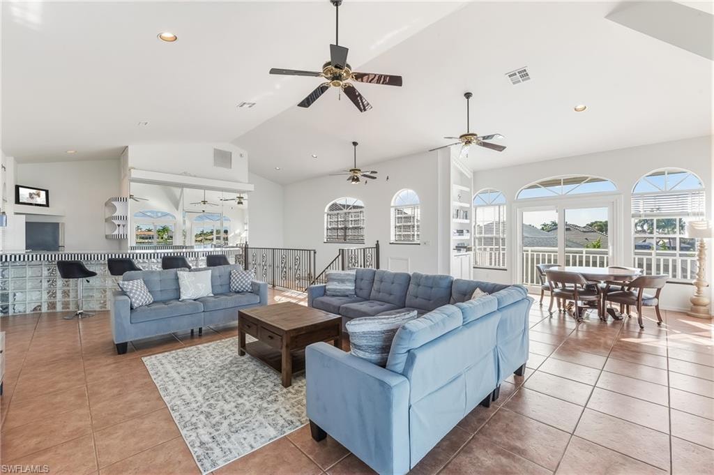 Living room featuring light tile patterned flooring, high vaulted ceiling, and recessed lighting