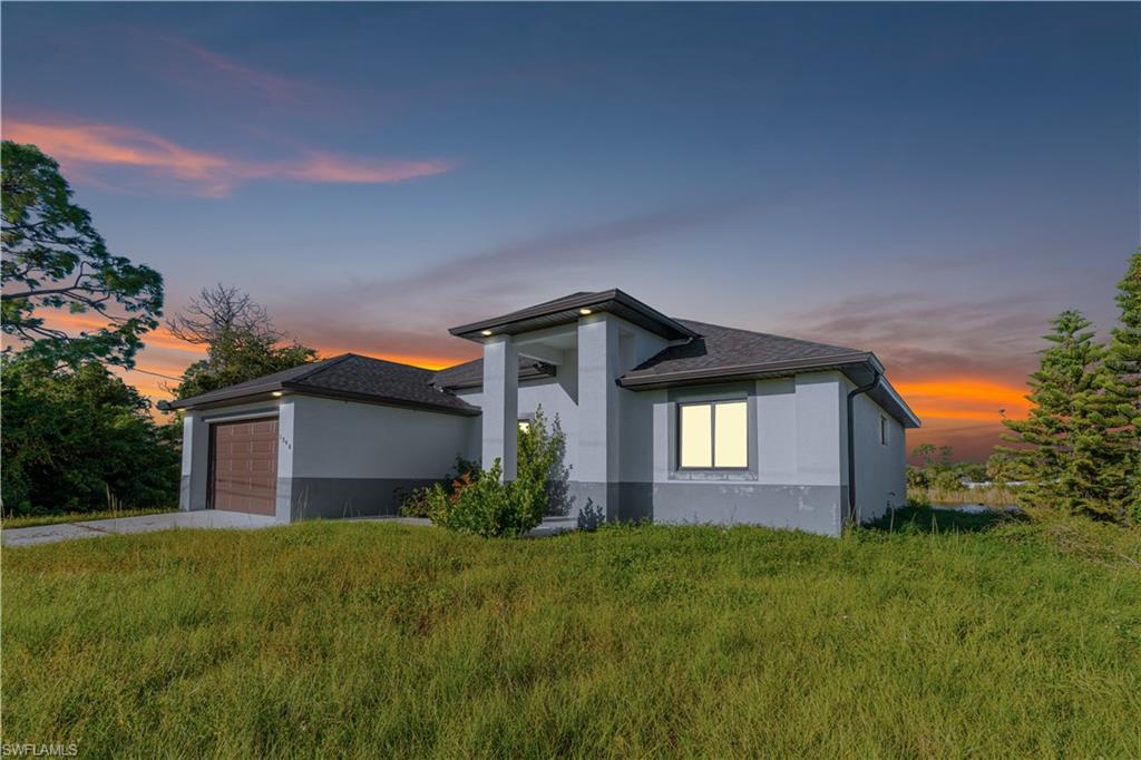 View of front of house with a garage, stucco siding, driveway, and roof with shingles