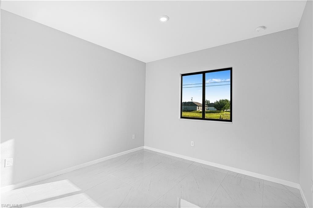 Empty room with baseboards and recessed lighting
