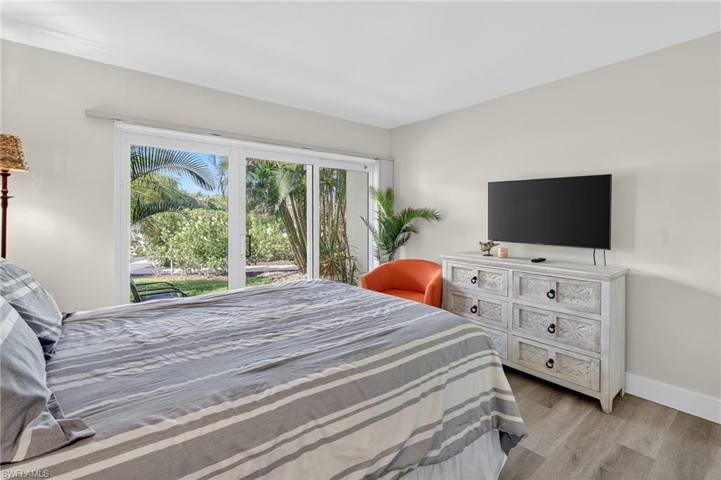 Bedroom with wood finished floors and access to outside